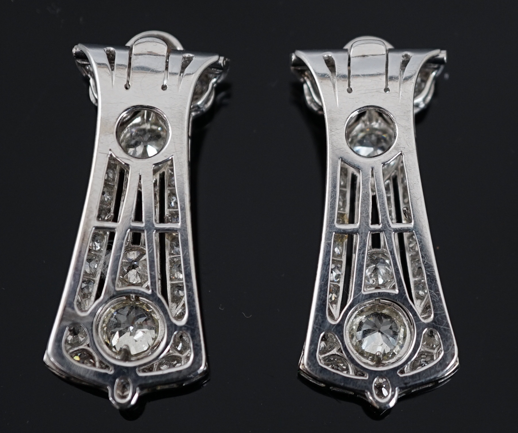 A pair of Art Deco white gold and round cut millegrain set diamond cluster clip brooches